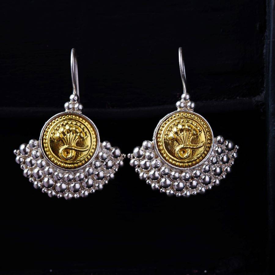a pair of gold and silver earrings