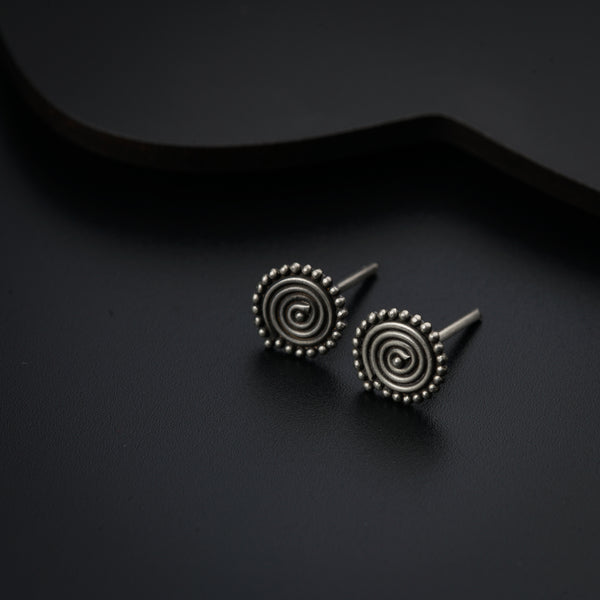 a pair of earrings sitting on top of a black surface