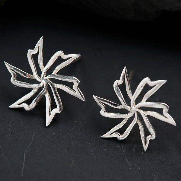 a pair of silver earrings sitting on top of a table