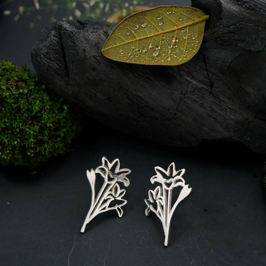 a pair of earrings with a leaf on top of it