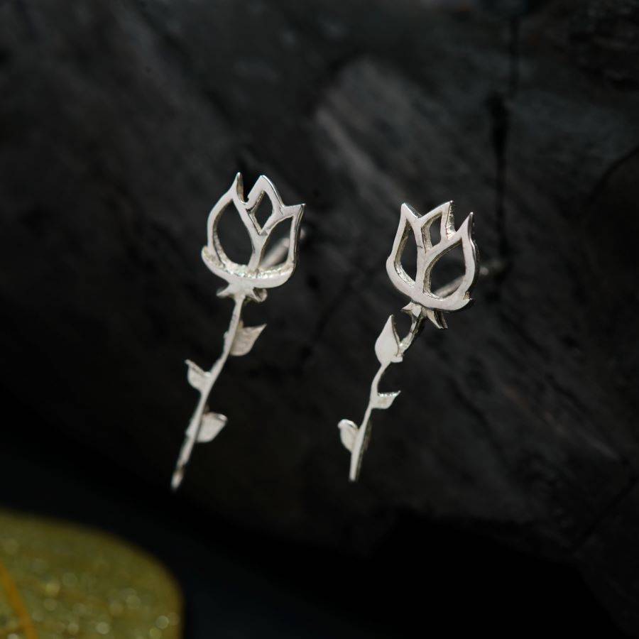 a pair of silver earrings with leaves on them
