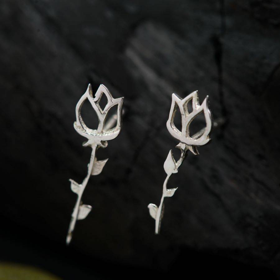 a pair of silver earrings with flowers on them