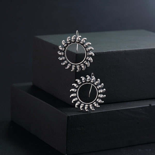 a pair of earrings sitting on top of a black box