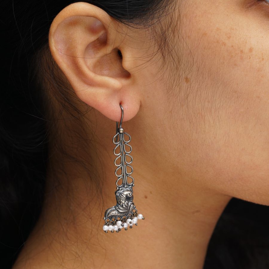 a close up of a person wearing a pair of earrings