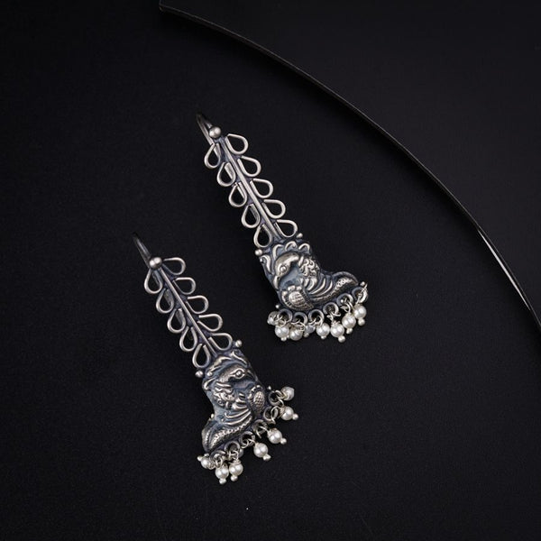 a pair of silver colored earrings on a black background