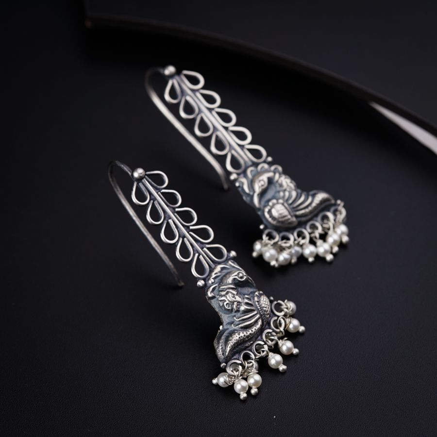 a close up of a pair of earrings on a black surface