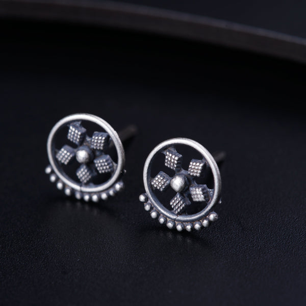 a pair of studded earrings sitting on top of a table