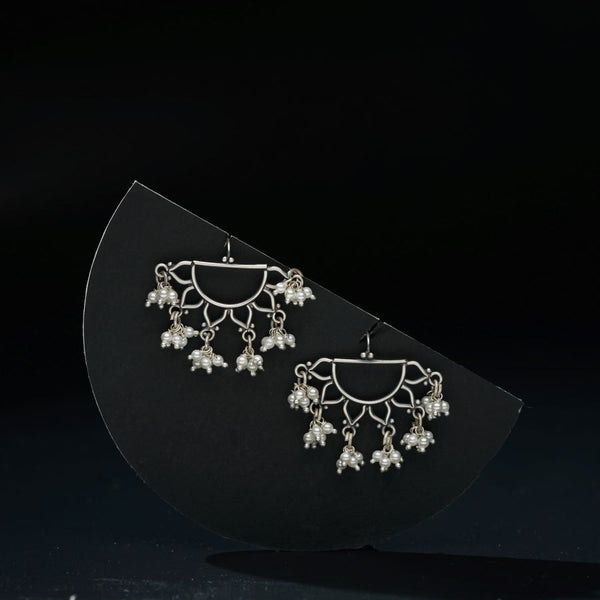 a pair of earrings sitting on top of a black surface