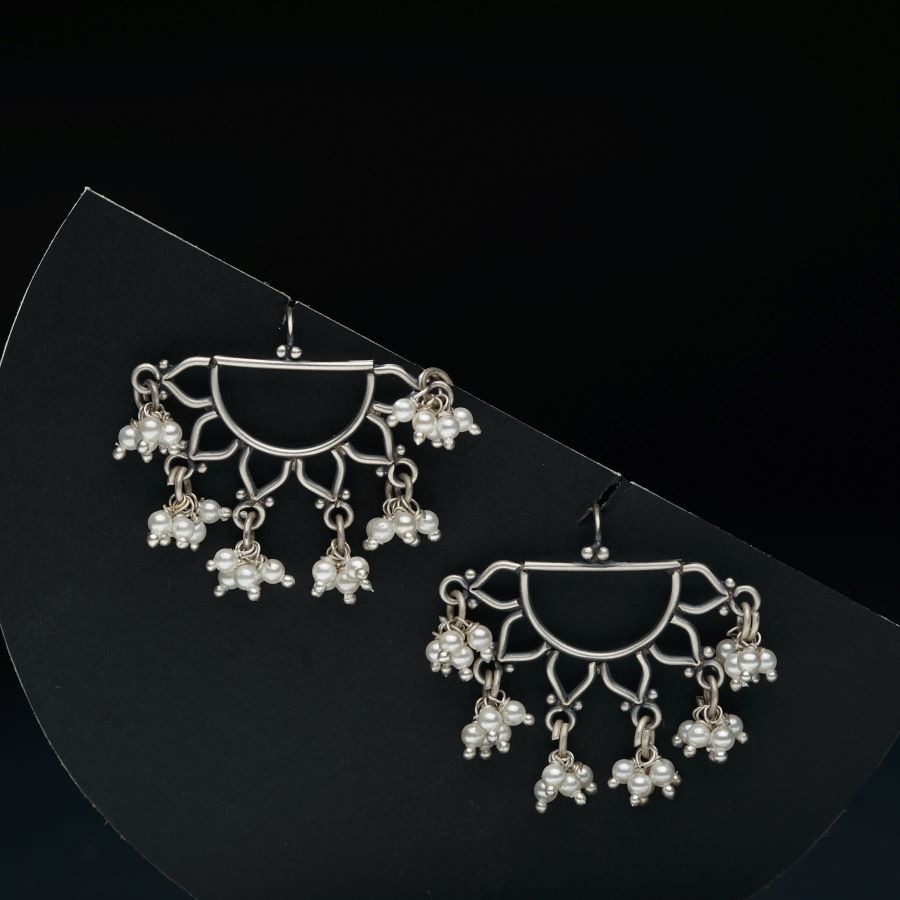 a pair of earrings on a black background