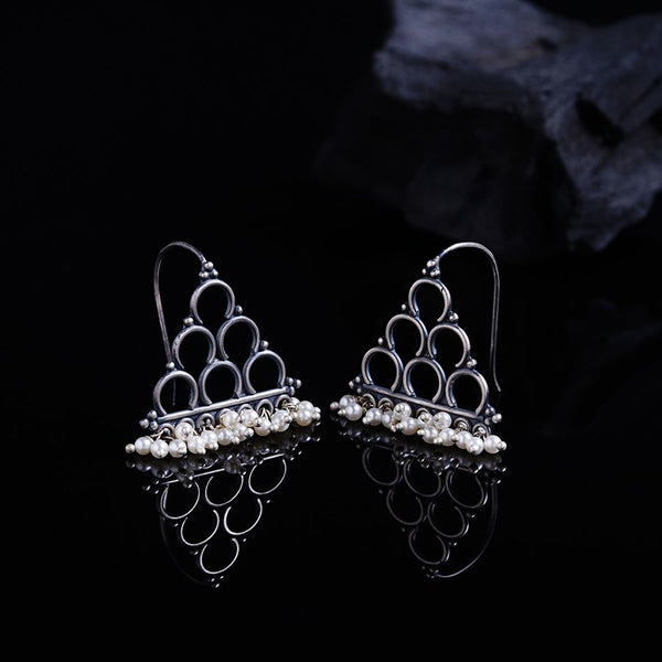 a pair of silver earrings with pearls