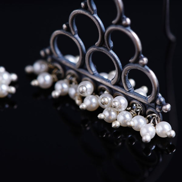 a tiara with pearls on a black surface