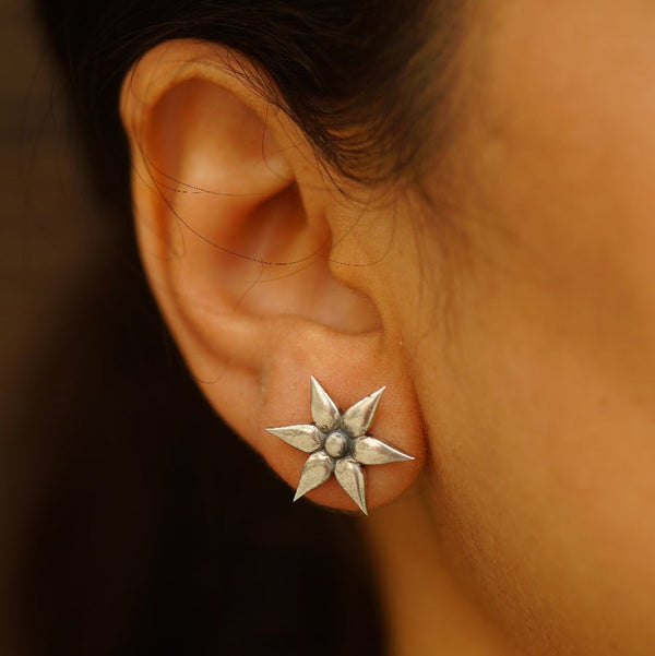 a close up of a person wearing a pair of earrings
