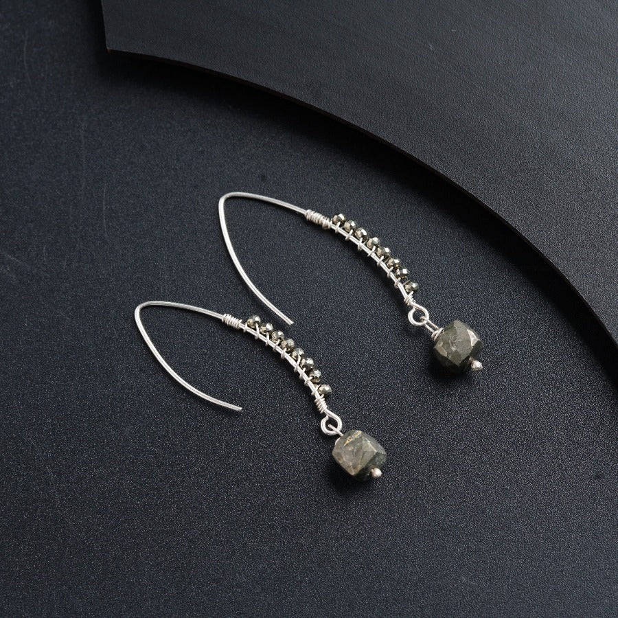 a pair of earrings on a black surface
