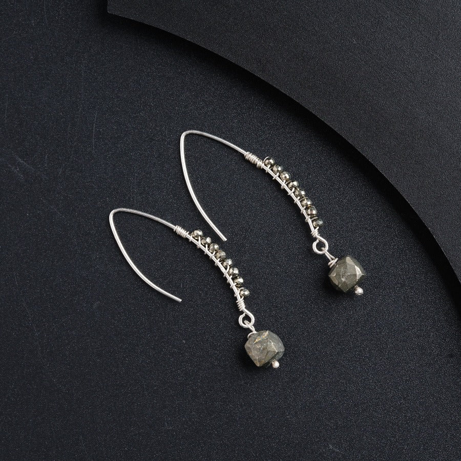 a pair of earrings on a black surface