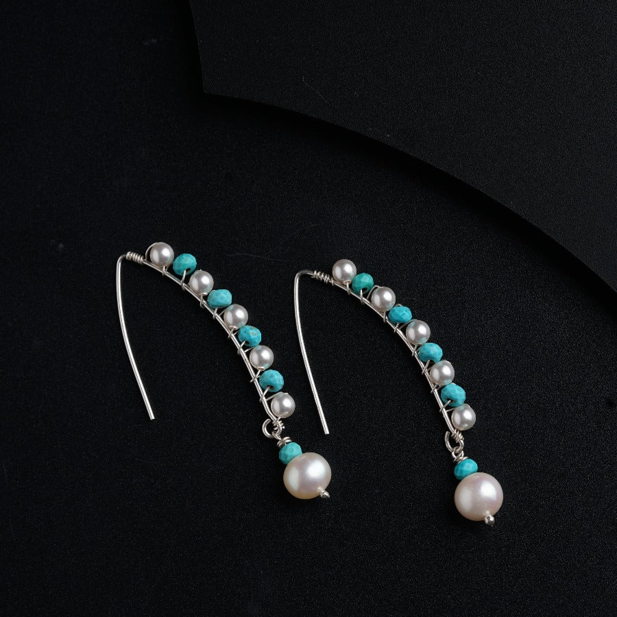 a pair of earrings with pearls and turquoise beads