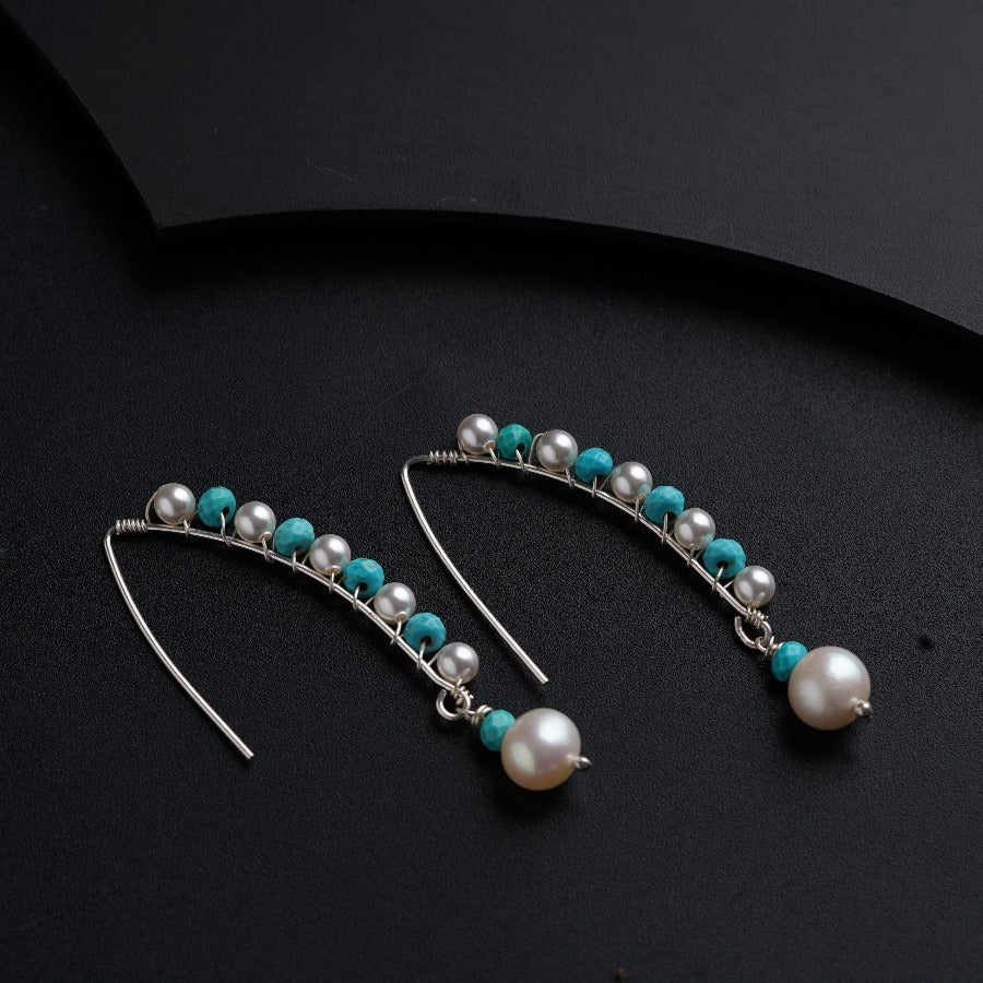 a pair of earrings with pearls and turquoise beads