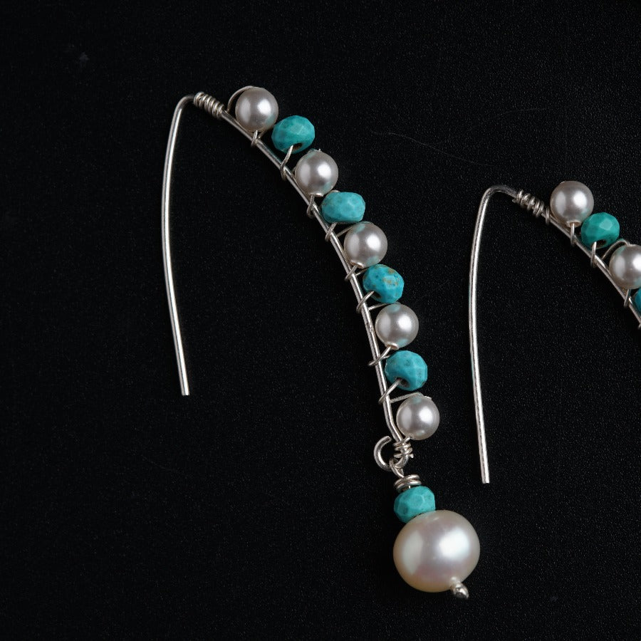 a pair of earrings with pearls and turquoise beads