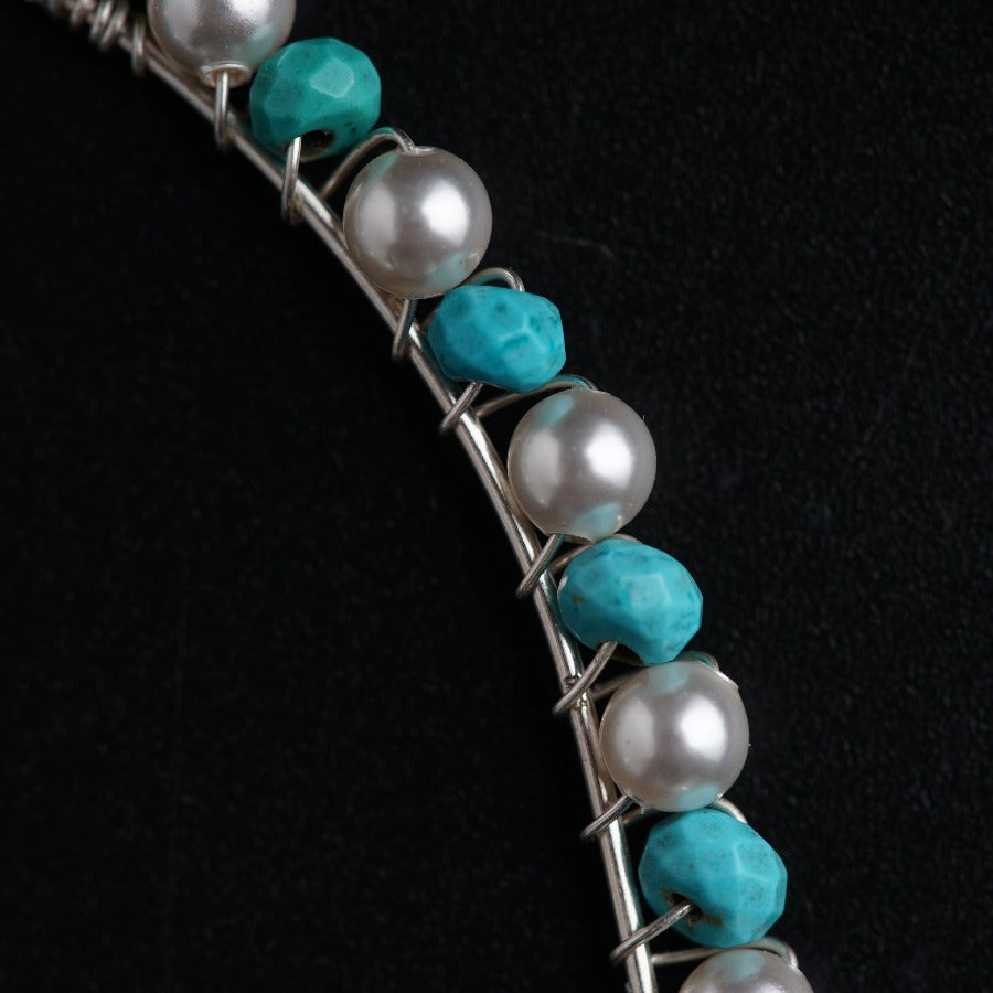 a necklace with pearls and turquoise stones