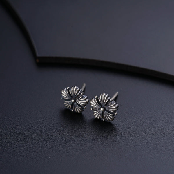 a pair of silver earrings sitting on top of a table