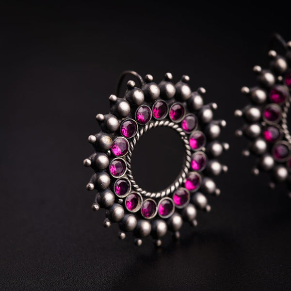 a close up of a pair of earrings on a black surface