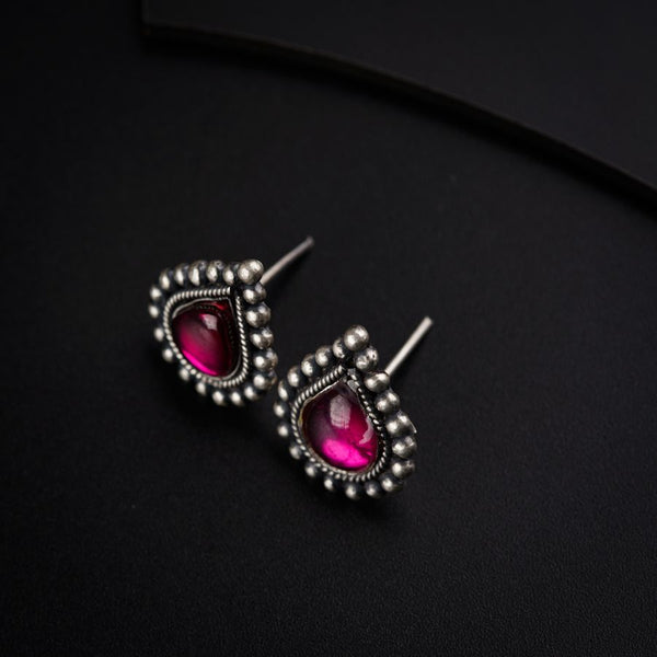 a pair of pink stone earrings on a black surface