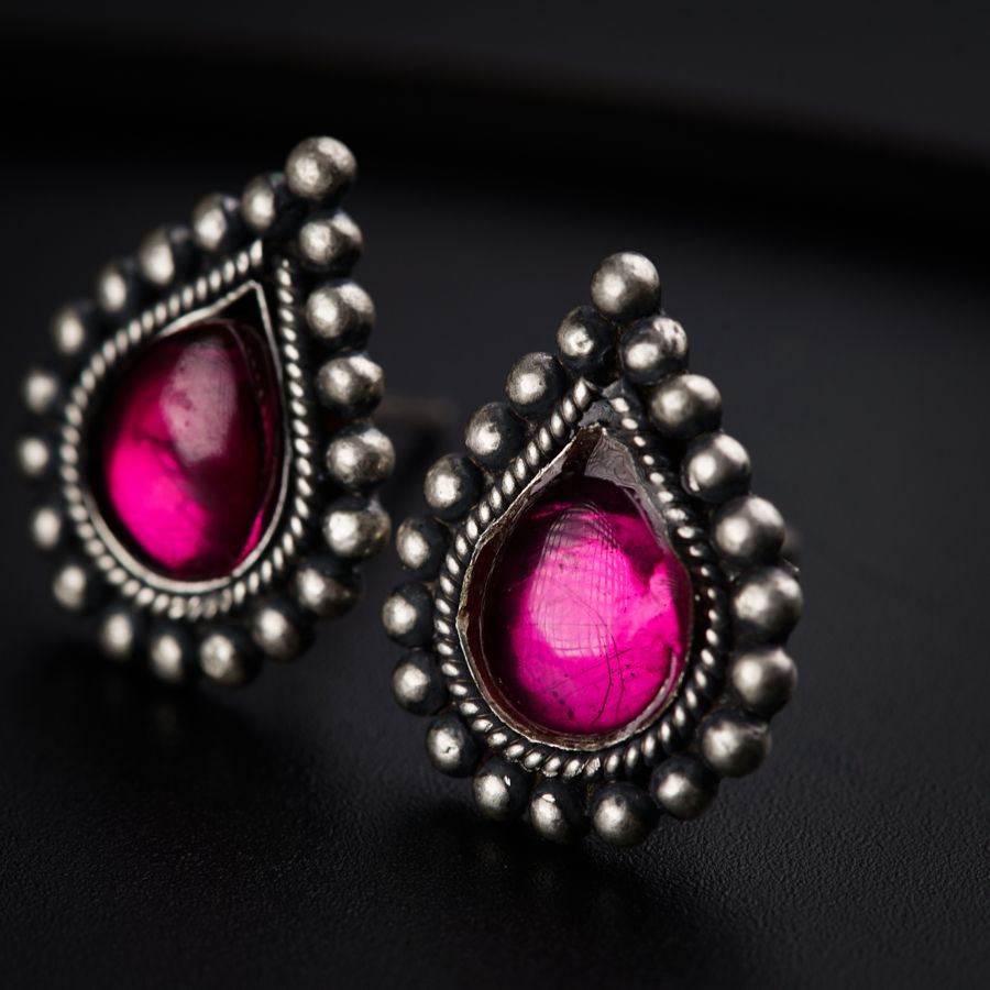 a pair of pink stone earrings on a black surface