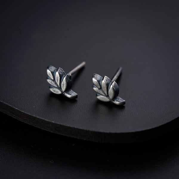 a pair of silver leaves on a black surface