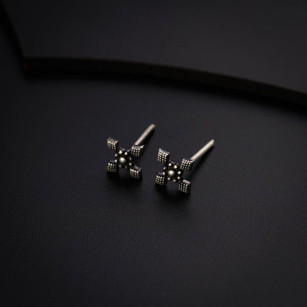 a pair of black and white earrings on a black surface