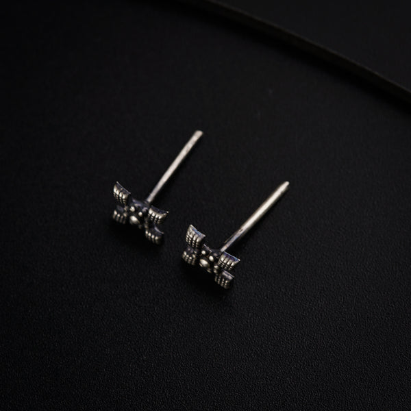 a pair of silver earrings on a black surface