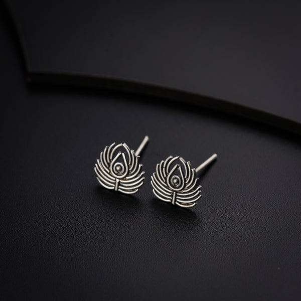 a pair of earrings sitting on top of a black surface