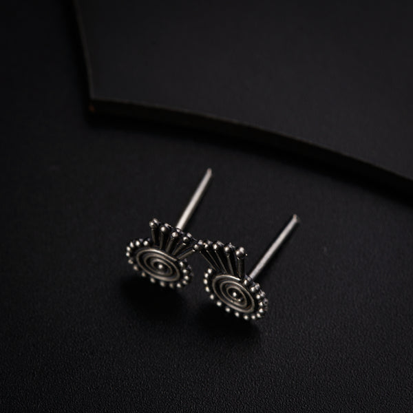 a pair of earrings sitting on top of a black surface