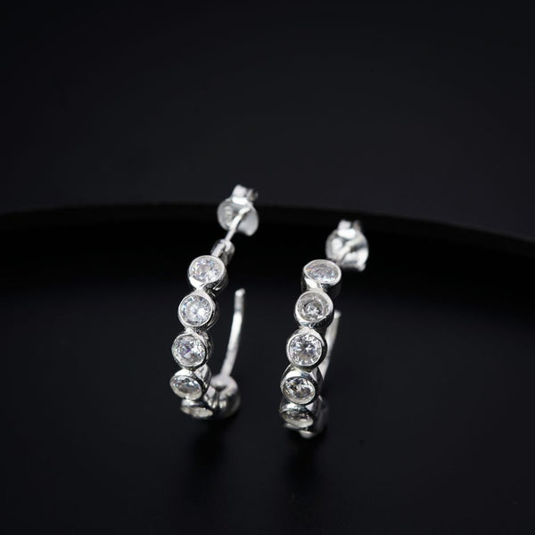 a pair of diamond hoop earrings on a black surface