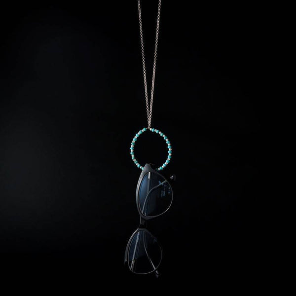 a blue beaded necklace with a black cat on it