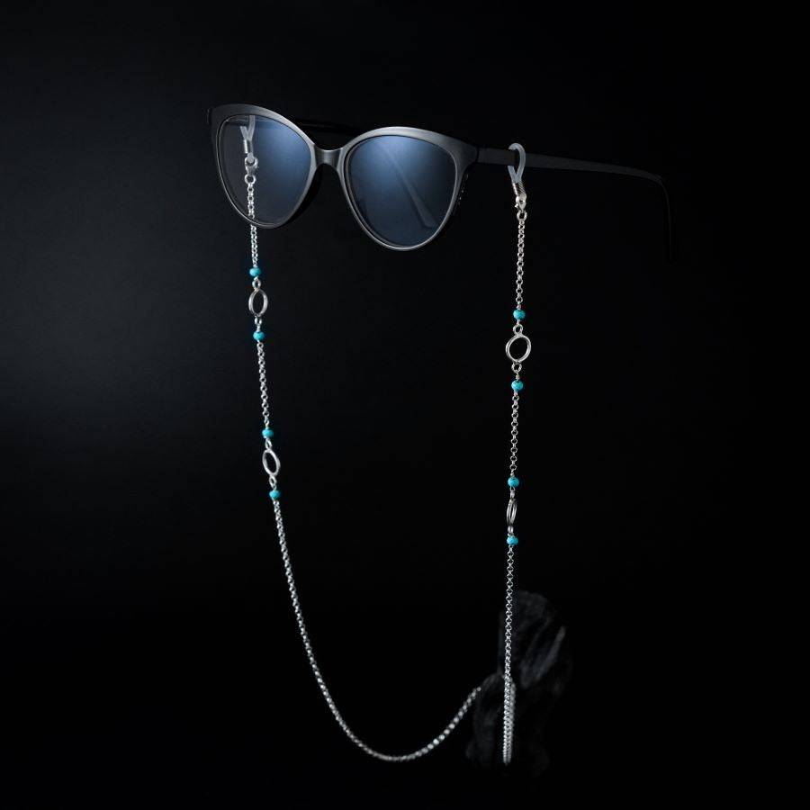 a pair of sunglasses and a chain on a black background