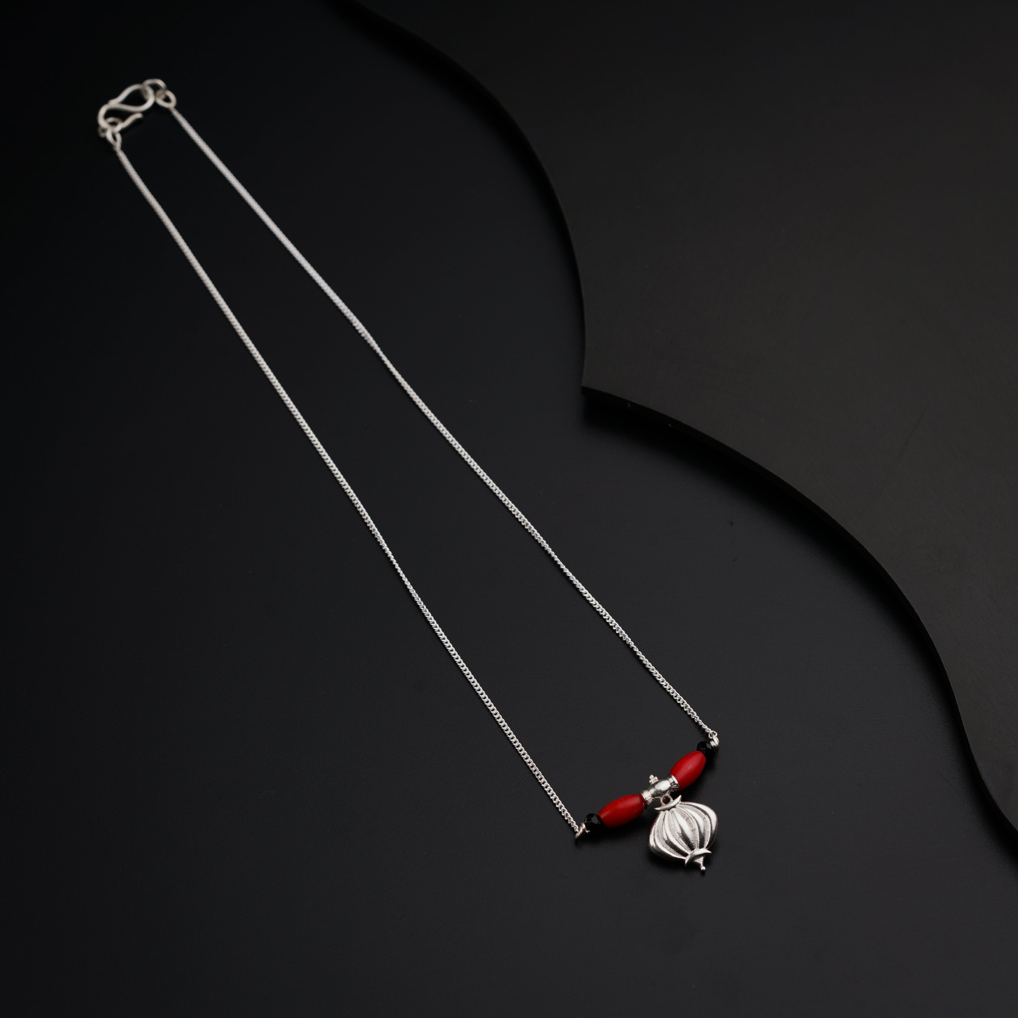 a red and white necklace on a black background