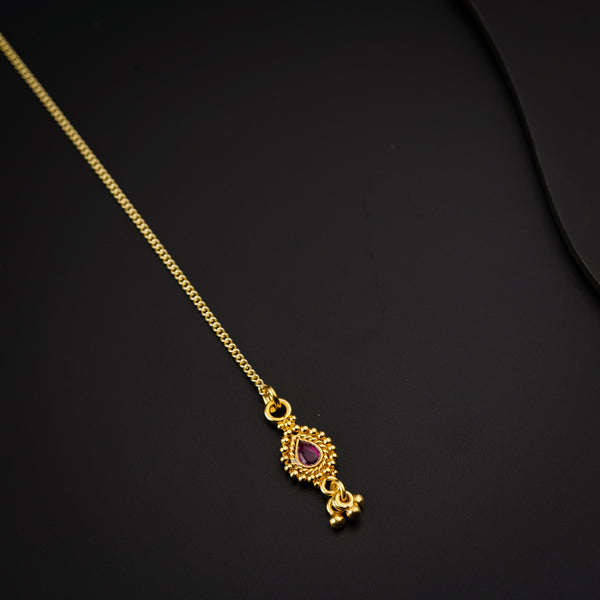 a gold necklace with a pink stone on it