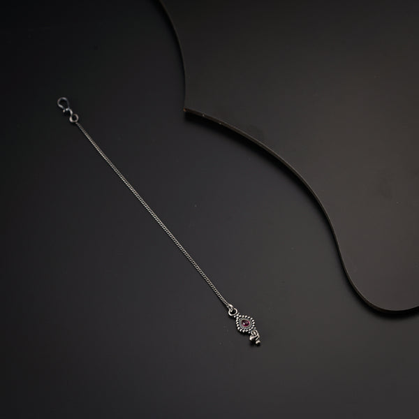 a silver necklace on a black background