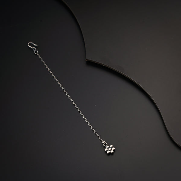 a black table with a silver necklace on it