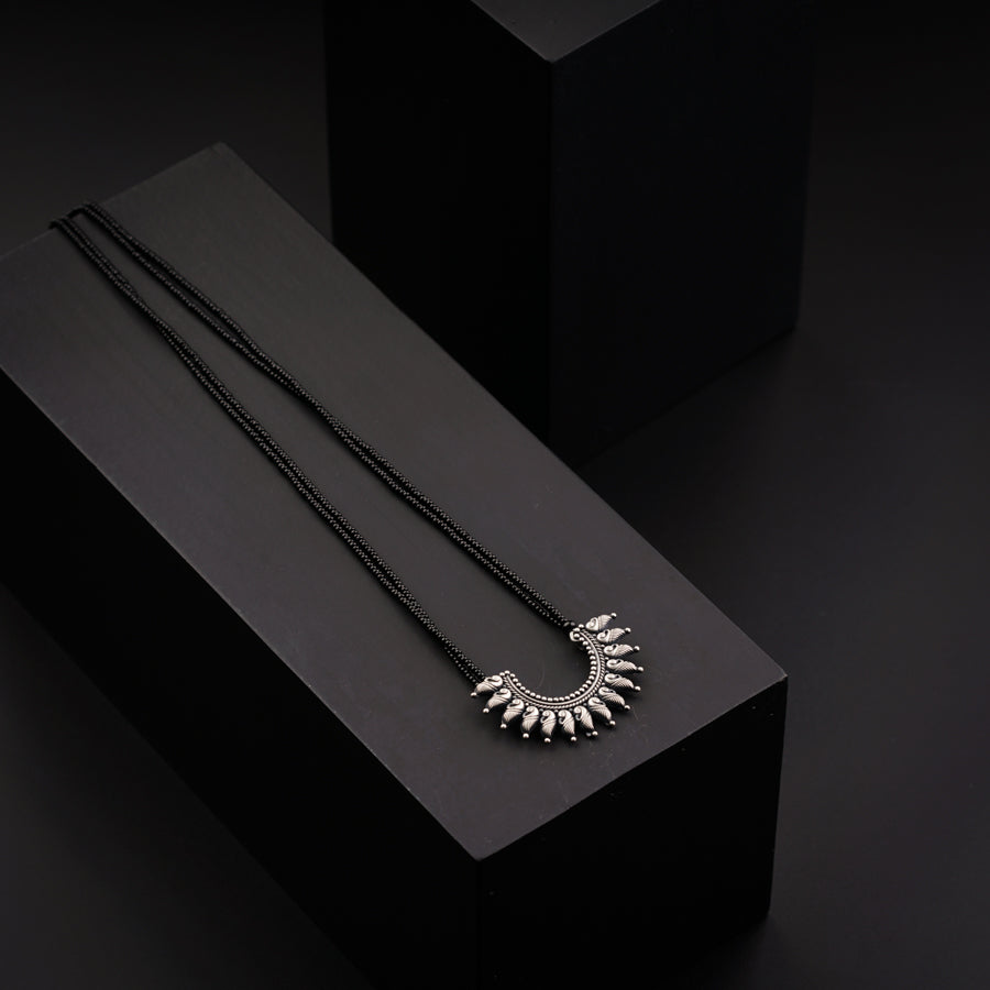 two necklaces sitting on top of a black box
