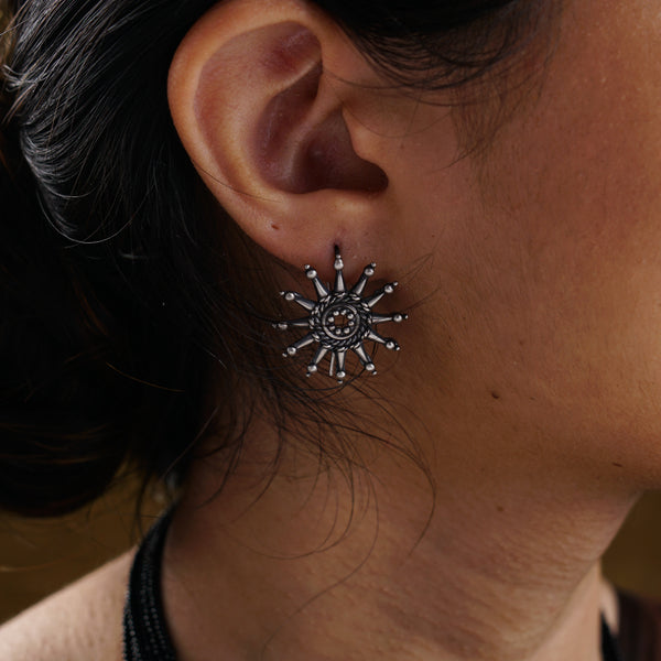 a close up of a person wearing a necklace and earrings