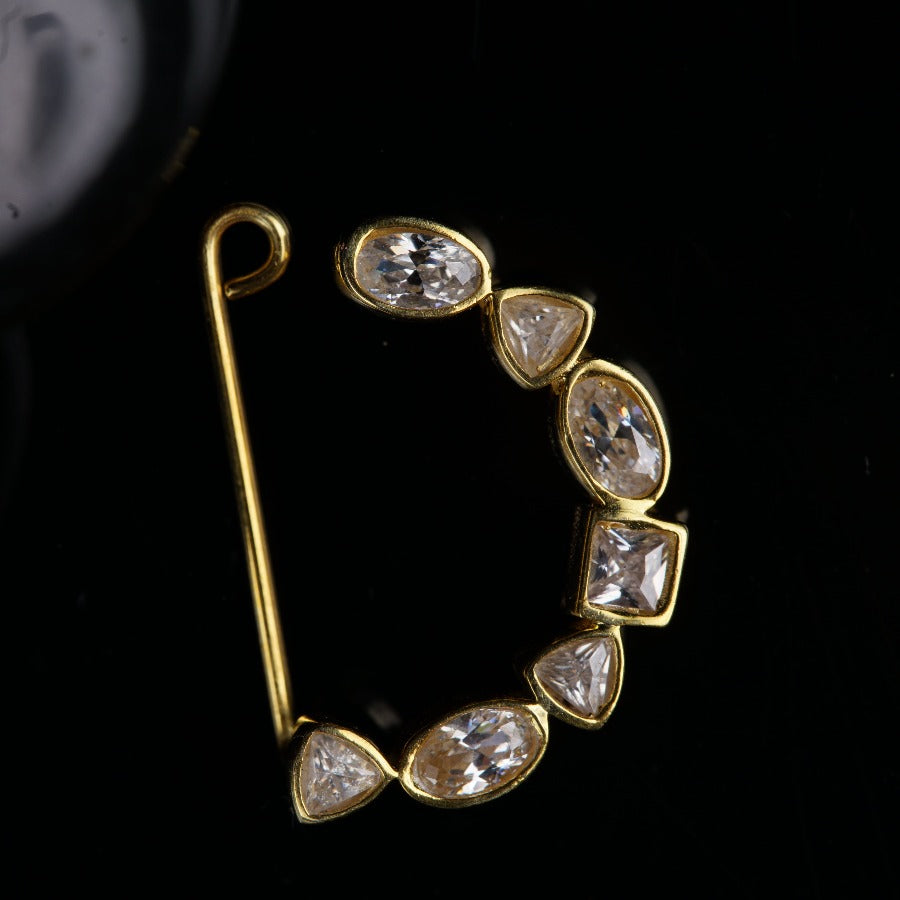 a gold brooch with diamonds on a black background