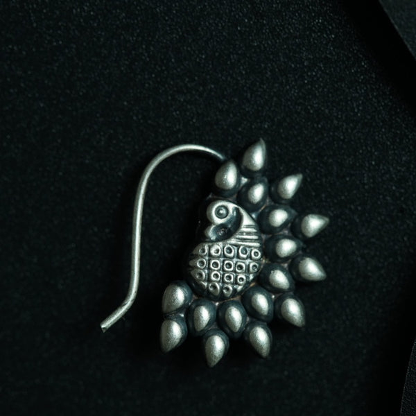 a close up of a brooch on a black surface