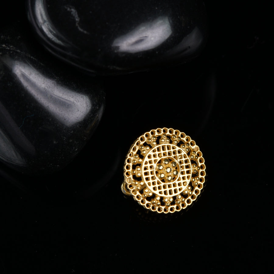 a gold ring sitting on top of a black rock
