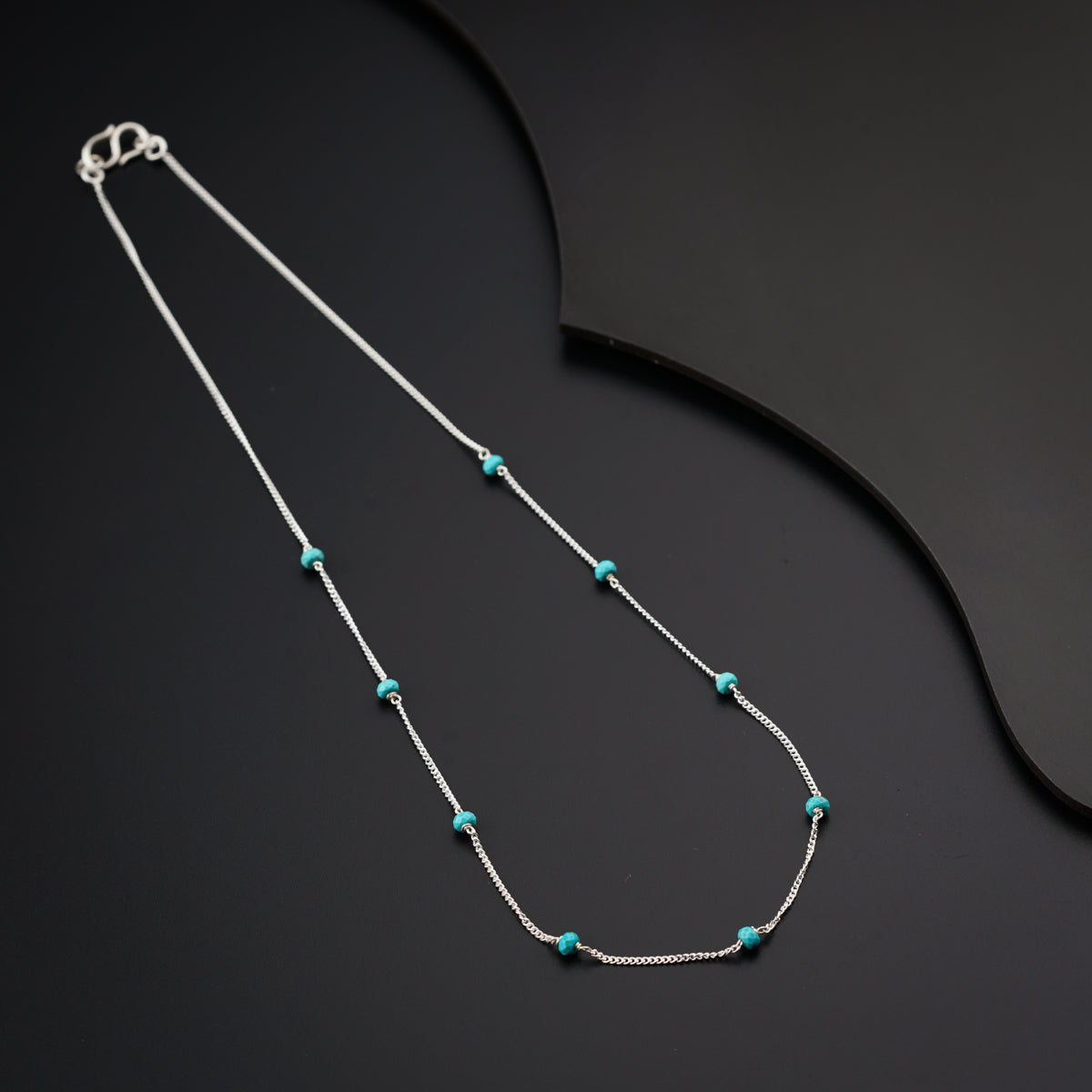 a necklace with turquoise beads and a silver chain