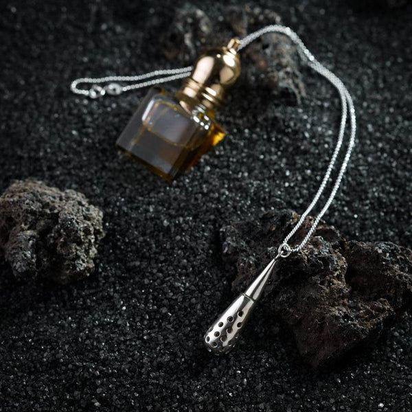 a bottle of perfume sitting on top of a rock