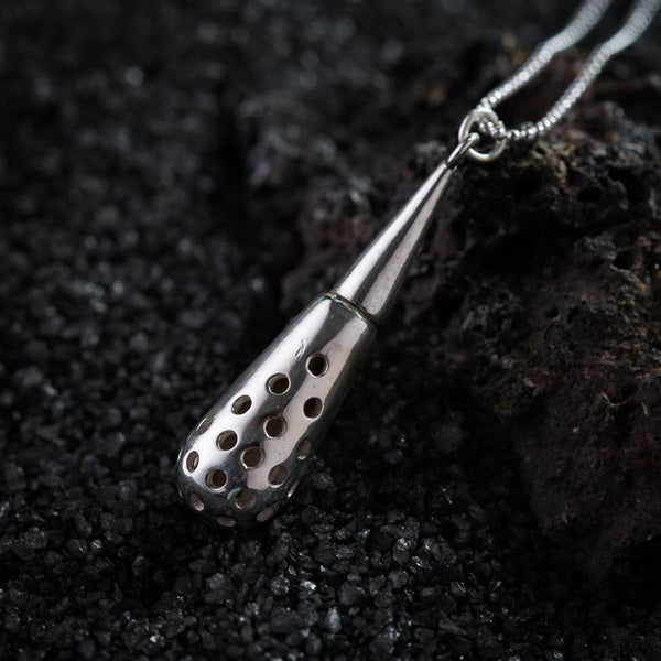 a close up of a metal object on a chain