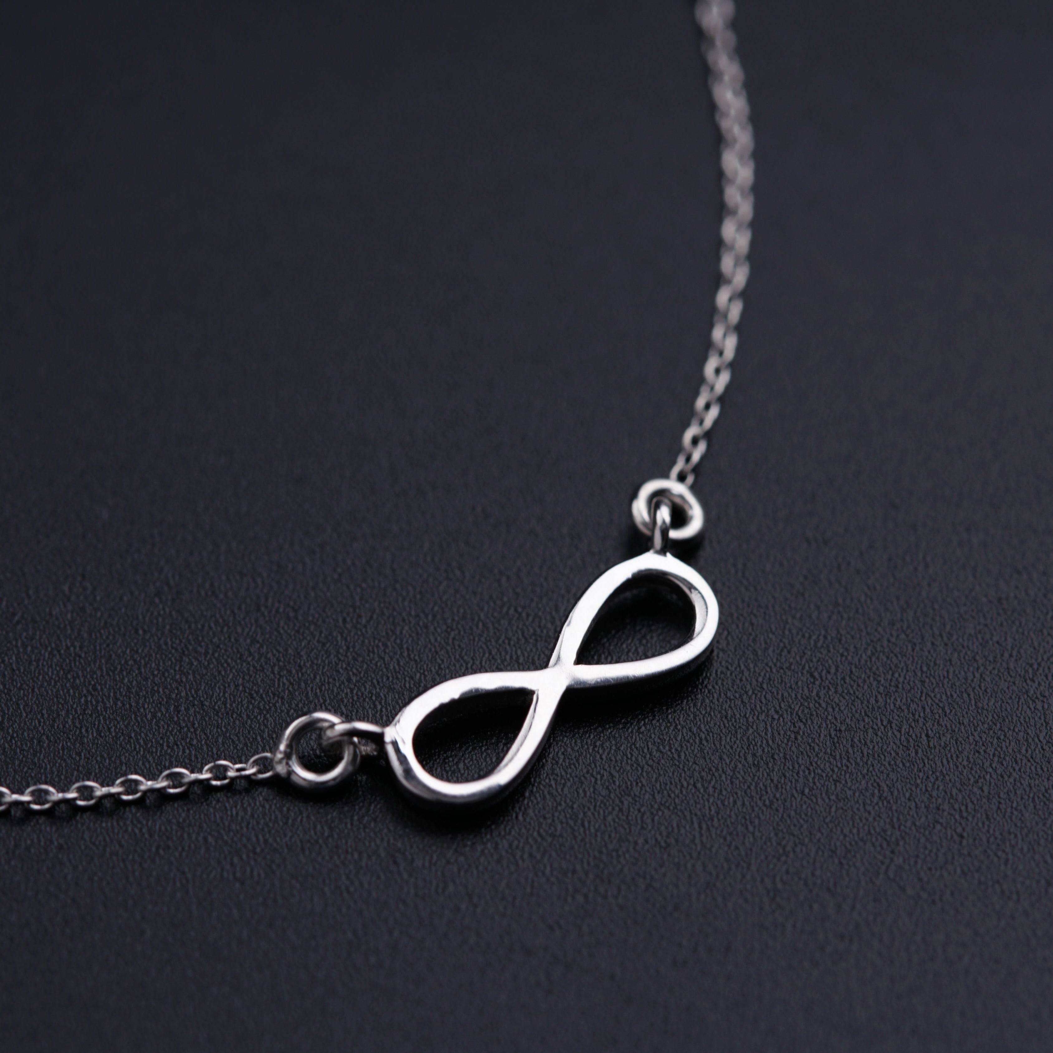 a silver necklace with an infinite symbol on it