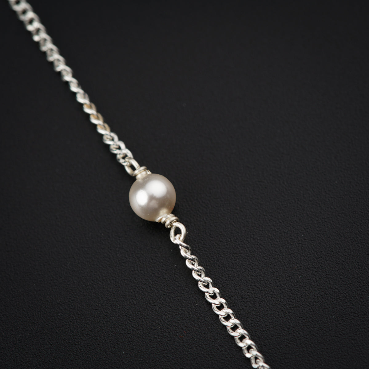 a necklace with a white pearl on a chain