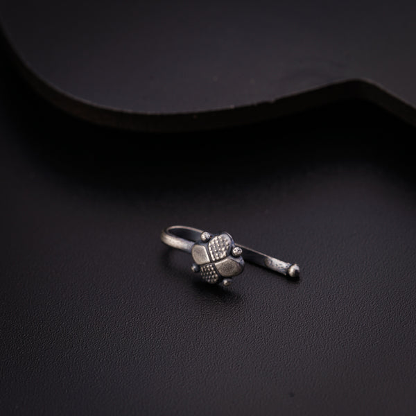 a small silver ring sitting on top of a black surface