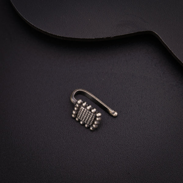 a pair of metal hooks sitting on top of a black surface